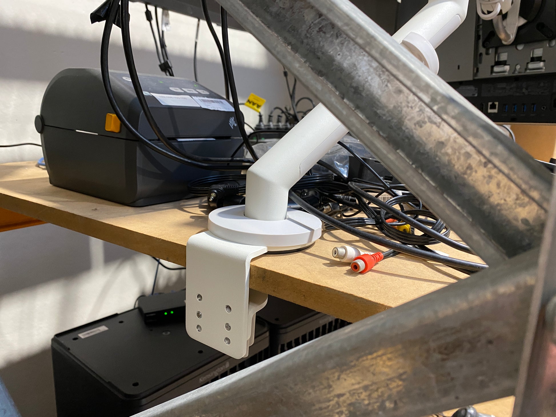 White mechanical arm on a wooden table with electronic components and tools.
